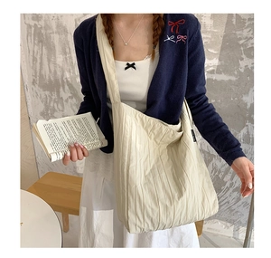 Dettaglio della grande borsa tote plissettata bianco off-white con tracolla larga