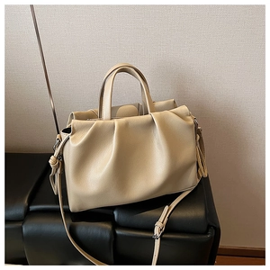 Detailaufnahme der beigen Beuteltasche mit Faltenwurf und strukturierter Lederoptik