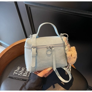 Light blue pleated mini bucket bag detail with plush bear charm and silver hardware