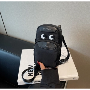 Detail of a black nylon crossbody bag featuring cartoon big eye embroidery and zipper