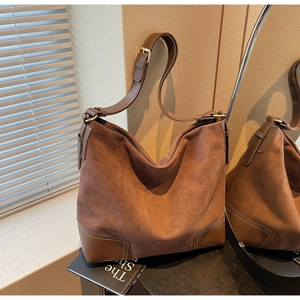 Close-up of vintage brown suede tote bag with leather straps and zipper detail