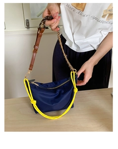 Detail of navy nylon crossbody bag with yellow rope accent and dual texture straps