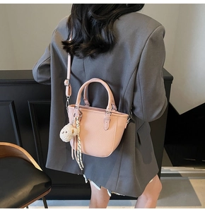 Detailed back view of a pink pebbled leather bucket bag with a cute sheep charm