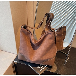 Detail of vintage brown suede tote bag with leather corner patches and gold hardware