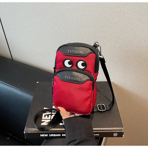 Detail of red and black crossbody phone bag with cartoon eyes and adjustable nylon strap