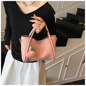 Detail of pink pebbled leather handbag featuring embossed Fashion and Bags lettering