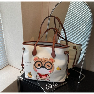 Close-up of white lychee leather tote bag with cute 3D bear embroidery and brown straps
