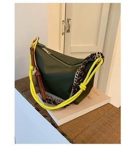 Detail of dark green Hobo bag showing yellow rope and metal chain shoulder strap
