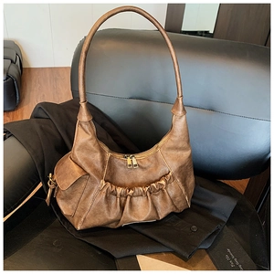 Close-up of vintage brown pleated underarm bag with high-quality synthetic leather texture