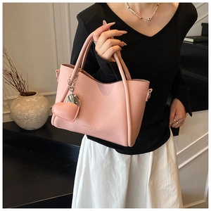 Pink lychee grain handbag with FASHION & BAGS text and heart pendant detail