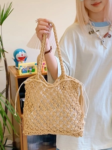 Large khaki straw woven tote bag with internal drawstring pouch and decorative tassels