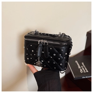 Detail of black quilted box bag featuring silver rhinestones and camellia charm
