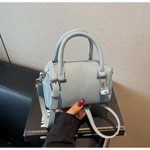 Close-up of light blue litchi grain leather mini Boston bag with silver hardware detail