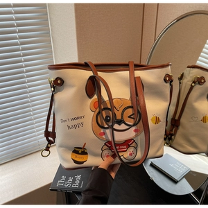Detail of cute bear print and honey embroidery on off-white leather tote bag