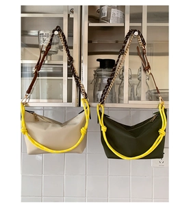 Detail of crescent shoulder bags in beige and olive with bold yellow rope handles