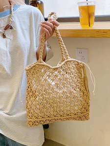 Large beige woven straw tote bag with drawstring inner pouch for summer beach vacations