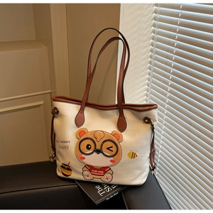 Close-up of the large white tote bag with bear print and litchi texture details
