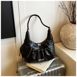 Close-up of black pleated underarm bag featuring MKMX metal logo and silver double zippers