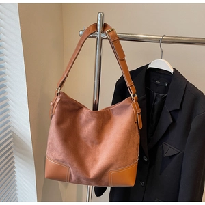 Detail of vintage large capacity brick red hobo bag with adjustable leather shoulder strap