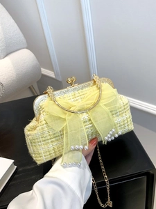 Yellow tweed shell bag with pearl bow decoration and golden handle for elegant styling