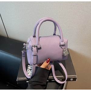 Macro shot of lavender litchi grain leather bag texture with silver padlock detail