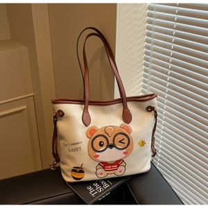 Macro shot of white leather tote bag featuring a 3D cartoon bear patch and happy text design