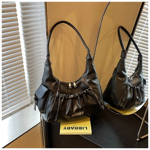Detail of black pleated shoulder bag with MKMX metal logo and retro leather texture