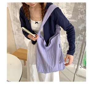 Dettaglio della trama pieghettata della borsa tote in tela lavanda con tracolla