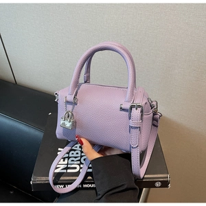 Close-up of lavender leather pillow bag featuring pebble texture and silver lock charm