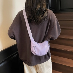 Lavender nylon crescent crossbody bag worn by model showing casual large capacity size