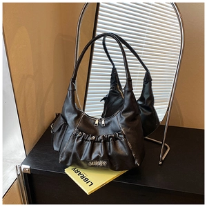 Detailed view of black pleated PU leather shoulder bag with silver MKMX metal logo plaque