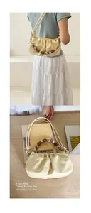 Detail of cream pleated underarm bag with beaded handle and smooth leather texture