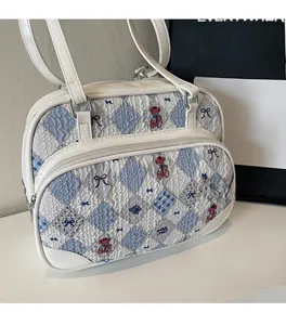 Close-up of quilted fabric texture with cute bear prints and bow details on white bag