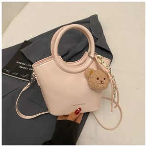 Pink bucket bag with FASHION & YM print, featuring a plush bear and woven decoration