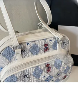 Close-up of quilted faux leather texture with teddy bear and bow prints on white handbag