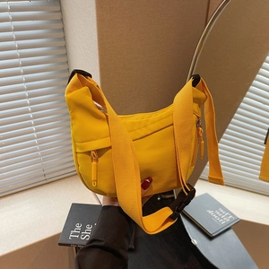 Detail of yellow crescent bag featuring wide nylon strap and adjustable buckle closure