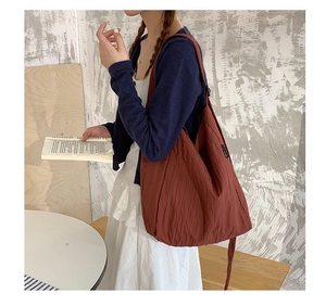 Dettaglio della borsa tote in tela rossa con texture a pieghe e drappeggio casual