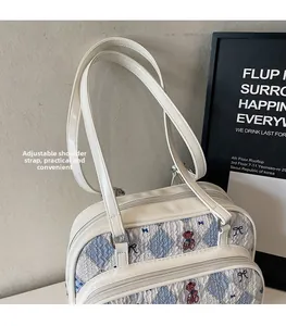 Detail view of adjustable shoulder strap and printed bear patterns on a tote bag
