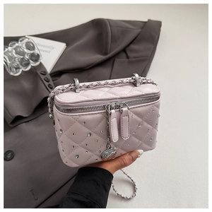 Detail of pink quilted box bag with sparkling rhinestones and silver rose chain strap