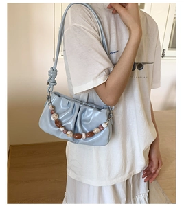 Detail of light blue pleated hobo bag with colorful marble bead chain and knot strap