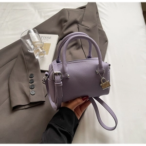 Detail of lavender mini boston bag in lychee texture leather with silver lock charm