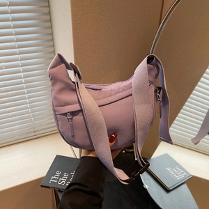 Purple nylon crescent bag featuring wide shoulder strap, black buckle, and front zipper pocket