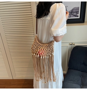 Detail of bohemian beige macramé hand-woven shoulder bag with tassels and decorative beads