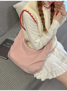 Close-up of pink large nylon hobo bag featuring a small white heart embroidery detail