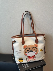 White leather tote bag with cartoon bear embroidery and brown handles for daily commute
