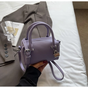 Detail of purple lychee leather pillow bag with silver lock and detachable strap