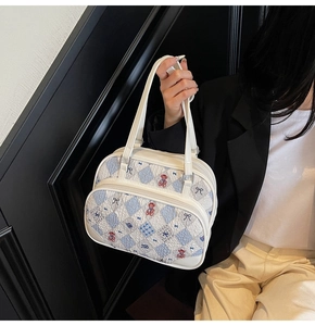 Detail of white quilted handbag with cute bear prints and double zipper design for women