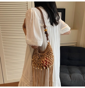 Detail of hand-woven mesh bag with brown leather strap and intricate wooden beads