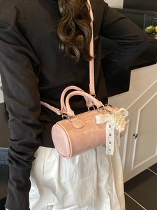 Pink vintage cylinder handbag with pleated leather texture and pearl heart charm