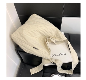 Dettaglio della trama a pieghe e del tessuto su una grande borsa tote color beige
